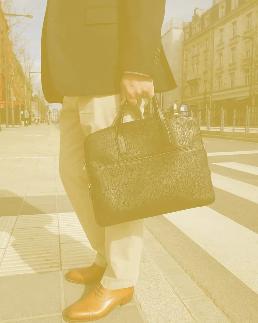 Consultant crossing a Luxembourg street, briefcase in hand