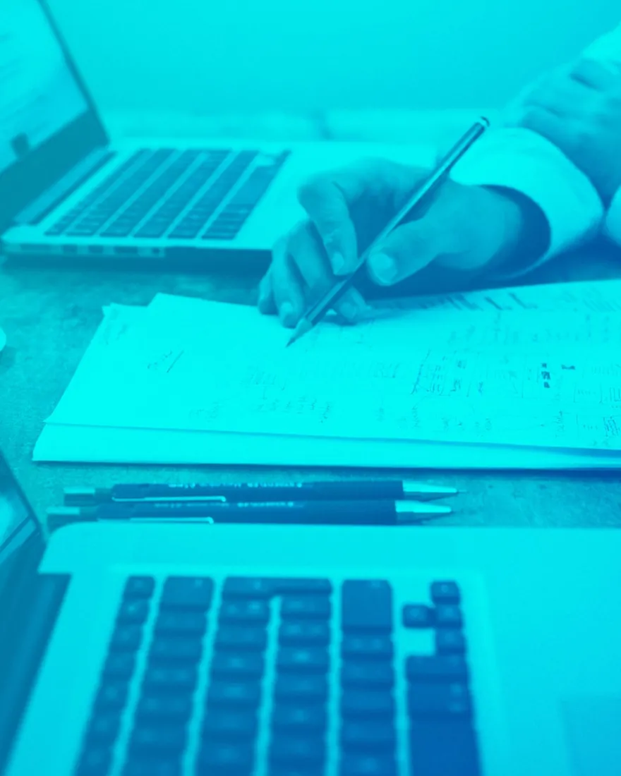 Blaue Duotone: handschriftliche Notizen neben einer Laptop-Tastatur